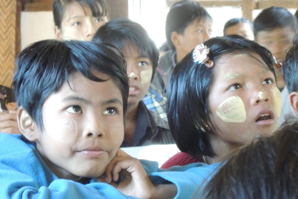 aufmerksame Kinder lauschen zwei burmesichen Lehrerinnen